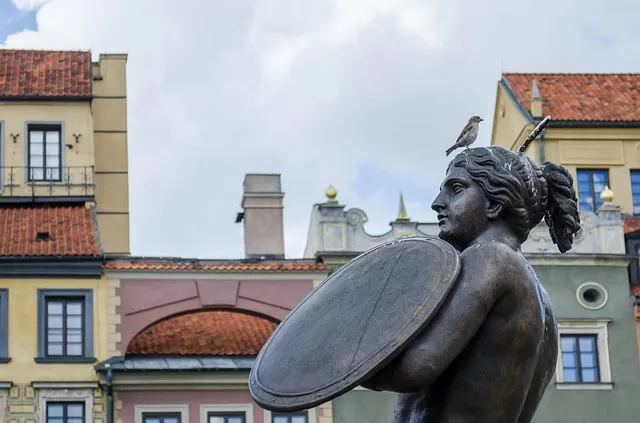 The Warsaw Mermaid statue holding a sword and shield in Warsaw's Old Town Market Square