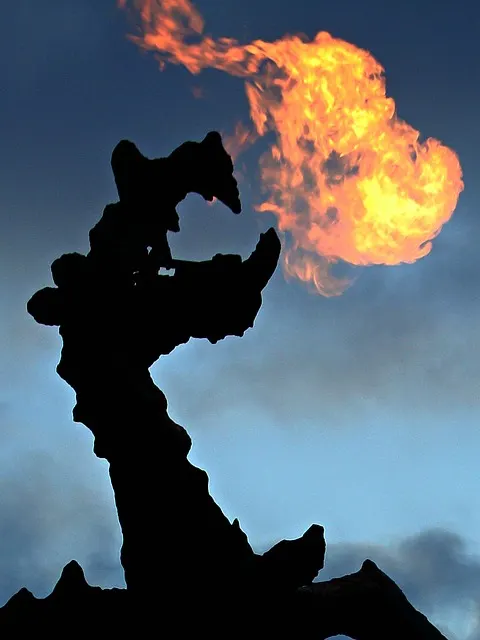 The bronze Wawel Dragon statue breathing real fire at the entrance to Smocza Jama in Krakow